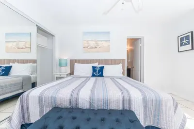 a bedroom with a large bed with blue and white sheets at 3Br W Oceanview Patio, 1 House From Popular 40Th St Beach By Beachview Rentals in Newport Beach
