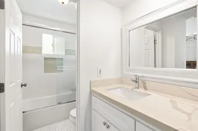 a white bathroom with a sink and a mirror at Stylish 3Br Bayfront Home W Balcony And Waterfront Views By Beachview Rentals in Newport Beach