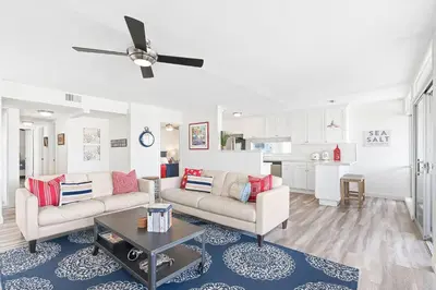 a living room with two couches and a table at Stylish 3Br Bayfront Home W Balcony And Waterfront Views By Beachview Rentals in Newport Beach