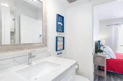 a bathroom with a sink and a mirror and a bed at Stylish 3Br Bayfront Home W Balcony And Waterfront Views By Beachview Rentals in Newport Beach