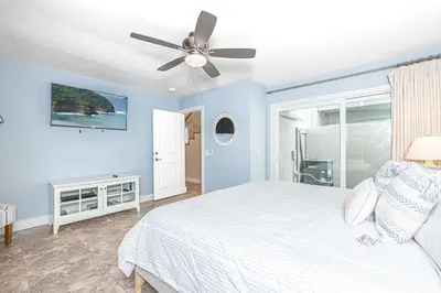 a bedroom with a white bed and a ceiling fan at Charming 2Br Condo W Ac, Steps To Beach And Balboa Pier By Beachview Rentals in Newport Beach