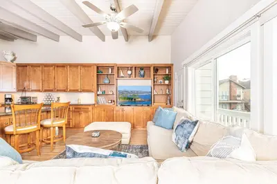 a living room with a couch and a kitchen at Charming 2Br Condo W Ac, Steps To Beach And Balboa Pier By Beachview Rentals in Newport Beach