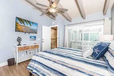 a bedroom with a bed and a ceiling fan at Charming 2Br Condo W Ac, Steps To Beach And Balboa Pier By Beachview Rentals in Newport Beach