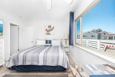 a bedroom with a bed and a large window at Spacious 4Br W Ocean Views And 2 Balconies, Steps To Sand By Beachview Rentals in Newport Beach