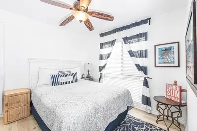 a bedroom with a bed and a ceiling fan at 3Br Bayfront W Expansive Front Patio - Easy Walk To Beach By Beachview Rentals in Newport Beach