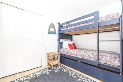 a bedroom with two bunk beds and a rug at 3Br Bayfront W Expansive Front Patio - Easy Walk To Beach By Beachview Rentals in Newport Beach