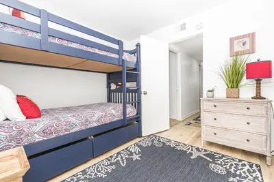 a bedroom with bunk beds and a dresser at 3Br Bayfront W Expansive Front Patio - Easy Walk To Beach By Beachview Rentals in Newport Beach