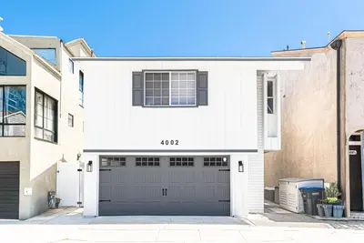 a white house with a garage at 3Br Bayfront W Expansive Front Patio - Easy Walk To Beach By Beachview Rentals in Newport Beach