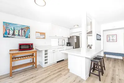 a kitchen with white cabinets and a counter top at 3Br Bayfront W Expansive Front Patio - Easy Walk To Beach By Beachview Rentals in Newport Beach