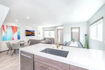 a kitchen with a sink and a living room at Modern 4Br Tri-Level W Rooftop Deck, Ac, Steps From Sand By Beachview Rentals in Newport Beach