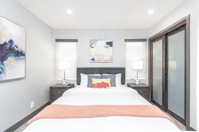 a bedroom with a large bed and two windows at Modern 4Br Tri-Level W Rooftop Deck, Ac, Steps From Sand By Beachview Rentals in Newport Beach