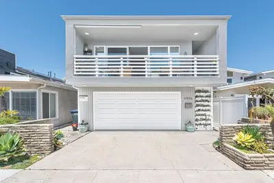 a large white house with a white garage at Affordable 2Br, Central Location, Walk To Beach And Dining By Beachview Rentals in Newport Beach