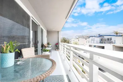 a balcony with a glass table and chairs at Affordable 2Br, Central Location, Walk To Beach And Dining By Beachview Rentals in Newport Beach