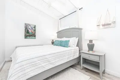 a white bedroom with a bed and a window at Remodeled 7Br Duplex Near Beach, Shops, And Dining By Beachview Rentals in Newport Beach