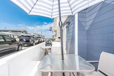a table with an umbrella on a balcony at Remodeled 7Br Duplex Near Beach, Shops, And Dining By Beachview Rentals in Newport Beach