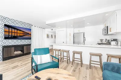 a kitchen and living room with a table and chairs at Remodeled 7Br Duplex Near Beach, Shops, And Dining By Beachview Rentals in Newport Beach