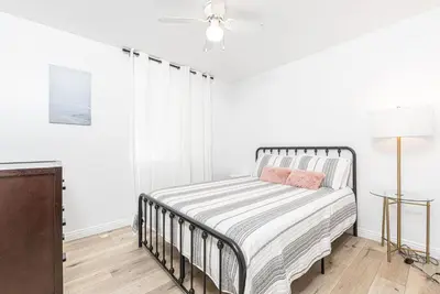 a white bedroom with a bed and a ceiling fan at Remodeled 7Br Duplex Near Beach, Shops, And Dining By Beachview Rentals in Newport Beach