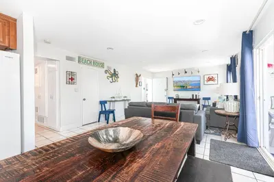 a living room with a table and a couch at Spacious 5Br W Oceanview Balcony - One House From Beach By Beachview Rentals in Newport Beach