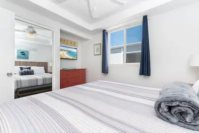a bedroom with a bed and a window at Spacious 5Br W Oceanview Balcony - One House From Beach By Beachview Rentals in Newport Beach