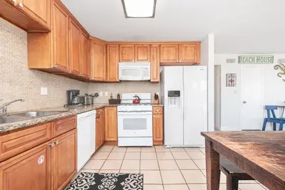 a kitchen with wooden cabinets and a white refrigerator at Spacious 5Br W Oceanview Balcony - One House From Beach By Beachview Rentals in Newport Beach