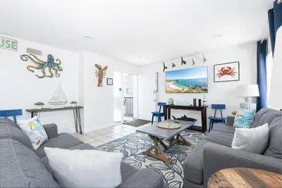 a living room with a couch and a table at Spacious 5Br W Oceanview Balcony - One House From Beach By Beachview Rentals in Newport Beach