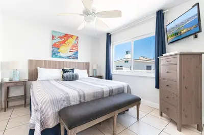 a bedroom with a bed with a ceiling fan and a window at Spacious 5Br W Oceanview Balcony - One House From Beach By Beachview Rentals in Newport Beach