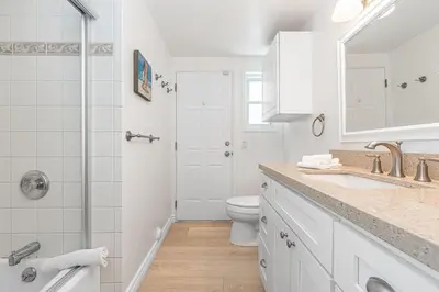 a white bathroom with a toilet and a sink at 7Br Duplex W Oceanview Balcony And Ac, Walk To It All By Beachview Rentals in Newport Beach