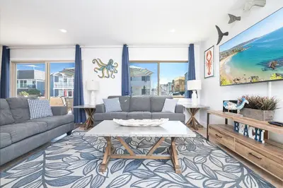 a living room with a couch and a table at 3Br W Spacious Oceanview Patio, Only One House From Sand By Beachview Rentals in Newport Beach