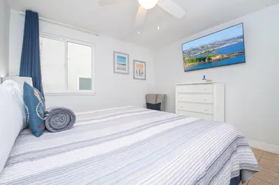 a white bedroom with a bed and a dresser at 3Br W Spacious Oceanview Patio, Only One House From Sand By Beachview Rentals in Newport Beach