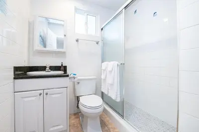 a white bathroom with a toilet and a glass shower at 3Br W Spacious Oceanview Patio, Only One House From Sand By Beachview Rentals in Newport Beach