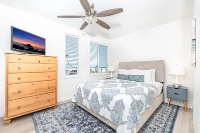 a bedroom with a bed and a ceiling fan at Remodeled 2Br Oceanfront W Spacious Patio, Stunning Views By Beachview Rentals in Newport Beach