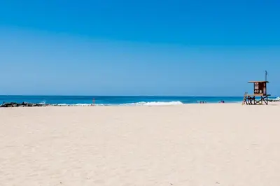 a beach with a lifeguard house and the ocean at Remodeled 2Br Oceanfront W Spacious Patio, Stunning Views By Beachview Rentals in Newport Beach