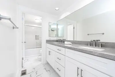 a white bathroom with a sink and a shower at Remodeled 2Br Oceanfront W Spacious Patio, Stunning Views By Beachview Rentals in Newport Beach