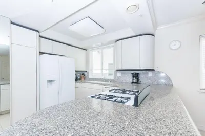 a kitchen with white appliances and a granite counter top at Steps To Sand! 7Br Retreat W Ocean Views In Prime Location By Beachview Rentals in Newport Beach