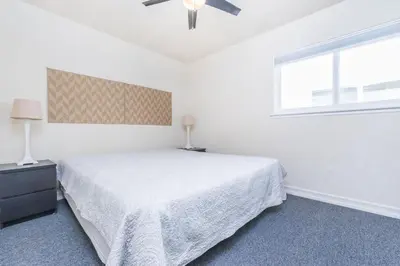 a white bedroom with a bed and a window at Steps To Sand! 7Br Retreat W Ocean Views In Prime Location By Beachview Rentals in Newport Beach