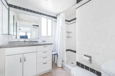 a white bathroom with a sink and a shower at Steps To Sand! 7Br Retreat W Ocean Views In Prime Location By Beachview Rentals in Newport Beach