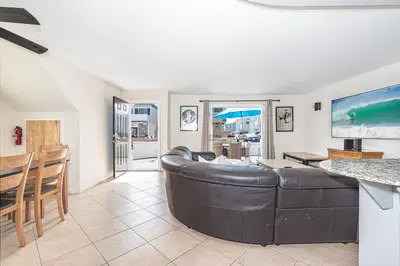 a living room with a leather couch and a table at Steps To Sand! 7Br Retreat W Ocean Views In Prime Location By Beachview Rentals in Newport Beach