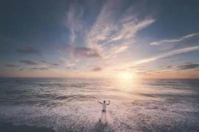 a person standing on the beach with their hands up at Steps To Sand! 7Br Retreat W Ocean Views In Prime Location By Beachview Rentals in Newport Beach
