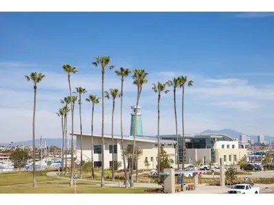 a group of palm trees in front of a building at Steps To Sand! 7Br Retreat W Ocean Views In Prime Location By Beachview Rentals in Newport Beach