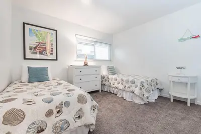 a bedroom with two beds and a dresser and a window at Spacious 4Br W Oceanview Balcony And Bbq, Steps To Sand By Beachview Rentals in Newport Beach