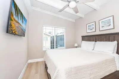 a bedroom with a white bed and a window at Stylish 6Br Duplex, One Block From Beach And Boardwalk By Beachview Rentals in Newport Beach