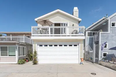 a house with a white garage door and a balcony at Darling 3Br Beach Home On Quiet Street, Easy Walk To Beach By Beachview Rentals in Newport Beach