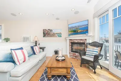a living room with a couch and a fireplace at Darling 3Br Beach Home On Quiet Street, Easy Walk To Beach By Beachview Rentals in Newport Beach