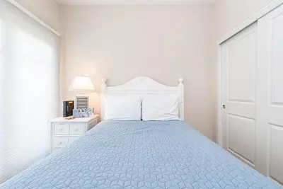 a white bedroom with a bed with a blue bedspread at Darling 3Br Beach Home On Quiet Street, Easy Walk To Beach By Beachview Rentals in Newport Beach
