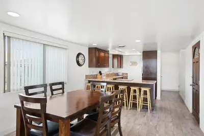 a kitchen and dining room with a wooden table and chairs at 5Br Coastal Retreat W Ocean Views - Steps From Beach By Beachview Rentals in Newport Beach