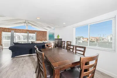a dining room with a table and a couch at 5Br Coastal Retreat W Ocean Views - Steps From Beach By Beachview Rentals in Newport Beach