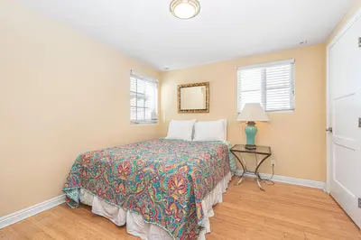 a bedroom with a bed and a table with a lamp at 3Br Oceanfront W Panoramic Views In Prime Central Location By Beachview Rentals in Newport Beach