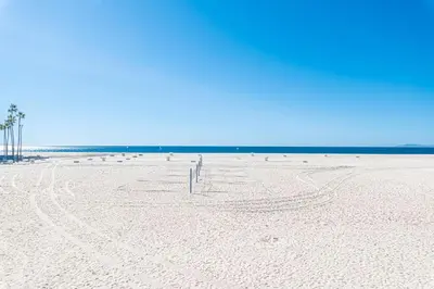 a beach with a person standing in the sand at 3Br Oceanfront W Panoramic Views In Prime Central Location By Beachview Rentals in Newport Beach