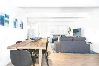 a living room with a table and a couch at Updated 2Br Cottage One House From Beach - Super Central By Beachview Rentals in Newport Beach