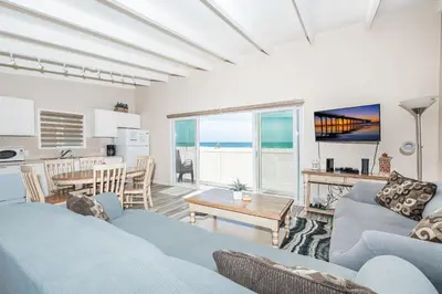 a living room with a couch and a table and a kitchen at 8Br Coastal Getaway W Gorgeous Views At An Excellent Value By Beachview Rentals in Newport Beach
